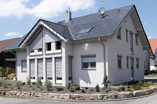 Graues Haus mit Schrägrollläden von Roma