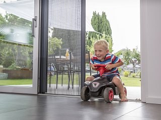 Spielendes Kind neben einer Insektenschutzlösung von Erfal